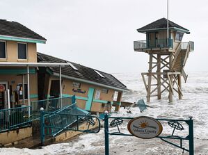 Durch den herannahenden Sturm «Nicole» verursachte Wellen schlagen in der Nähe eines beschädigten Gebäudes und eines Rettungsschwimmerturms auf., © Paul Hennessy/SOPA Images via ZUMA Press Wire/dpa