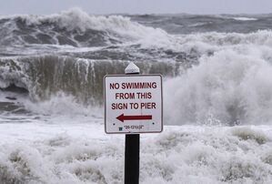 Ein Schild mit der Aufschrift «Schwimmen verboten» steht vor den Wellen in Daytona Beach. Der Sturm «Nicole» steuert auf die Ostküste der USA zu., © Paul Hennessy/SOPA Images via ZUMA Press Wire/dpa