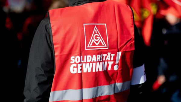 Ein Teilnehmer einer Kundgebung der IG Metall trägt eine rote Weste mit der Aufschrift «Solidarität gewinnt!»., © Hauke-Christian Dittrich/dpa/Archivbild