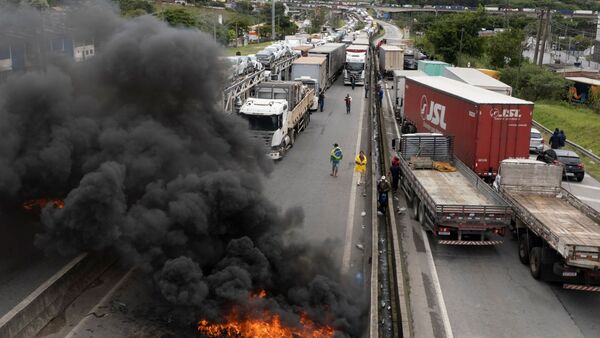 Anhänger des ehemaligen brasilianischen Präsidenten Bolsonaro blockieren eine Autobahn bei Itaborai., © Andre Penner/AP/dpa