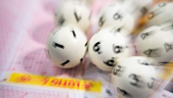 Lotto-Kugeln liegen auf einem Lottoschein., © Tom Weller/dpa/Symbolbild