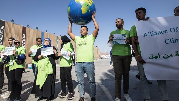 Demonstranten halten eine Weltkugel hoch während einer Demonstration der ägyptischen Allianz der zivilen Kräfte für den Klimawandel am Rande der UN-Weltklimakonferenz COP27., © Gehad Hamdy/dpa