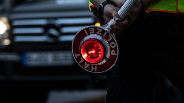 Ein Polizist hält bei einer Verkehrskontrolle eine Winkerkelle in der Hand., © Paul Zinken/dpa/Symbolbild