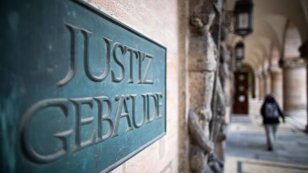 Ein Schild mit der Aufschrift «Justizgebäude» hängt am Eingang vom Landgericht Nürnberg-Fürth., © Peter Kneffel/dpa