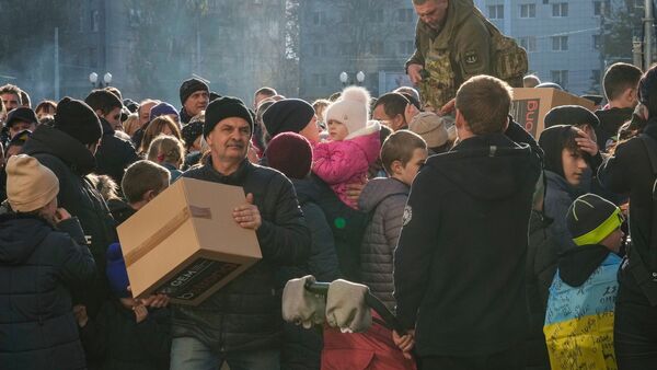 Menschen erhalten humanitäre Hilfe auf einem zentralen Platz in Cherson. Nach den wohl massivsten russischen Raketenangriffen auf die ukrainische Energieinfrastruktur seit Kriegsbeginn hat Kiew die Situation als «kritisch» bezeichnet., © Efrem Lukatsky/AP/dpa
