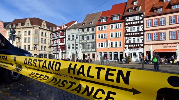 «Abstand halten!» steht in deutscher und englischer Sprache auf einem Flatterband am Domplatz inmitten der Altstadt von Erfurt., © Martin Schutt/dpa-Zentralbild/dpa