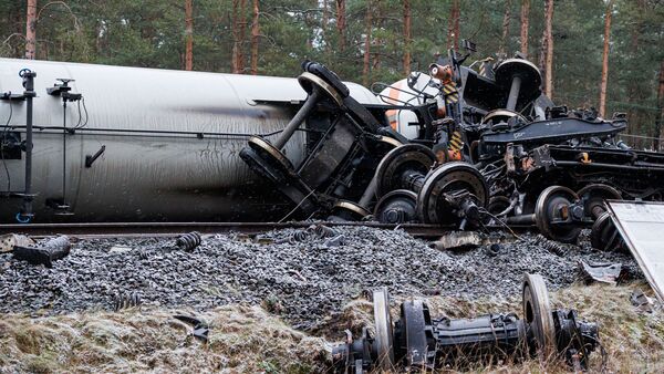 Mehrere Radachsen der verunfallten Güterzüge liegen verstreut auf und abseits der Schienen., © Michael Matthey/dpa