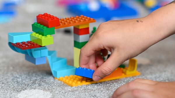 Ein Kind baut mit Lego-Steinen., © Tobias Hase/dpa/Symbolbild